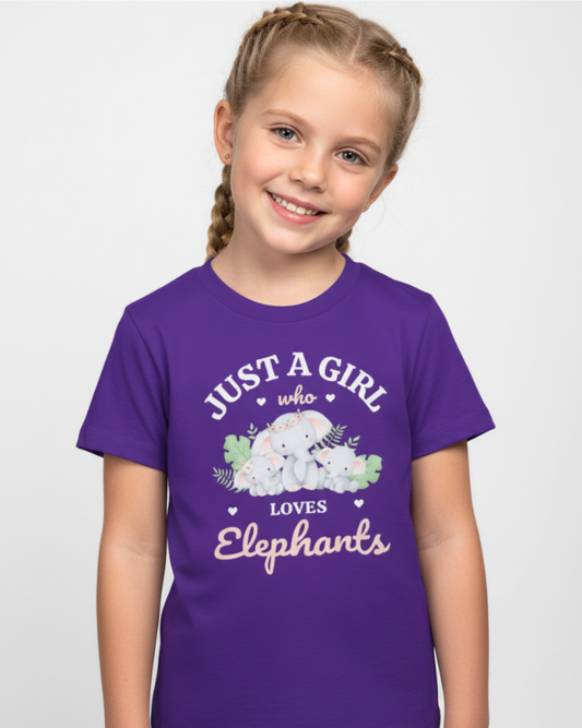 Smiling girl wearing a purple “Just a Girl Who Loves Elephants” kids t-shirt with cute elephant illustration, studio photo on a light grey background.