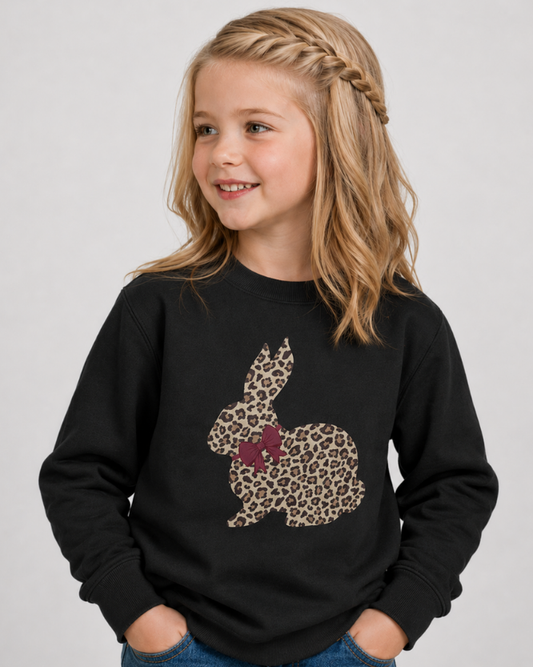 Girl wearing black leopard bunny kids sweatshirt with braided hairstyle in studio setting