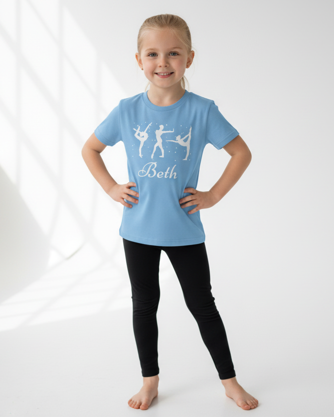 Girl modelling light blue personalised gymnastics t-shirt with name Beth and black leggings.