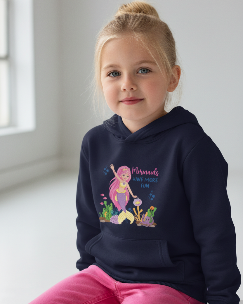 Young girl wearing navy blue mermaid hoodie with “Mermaids Have More Fun” print, studio portrait with natural window lighting