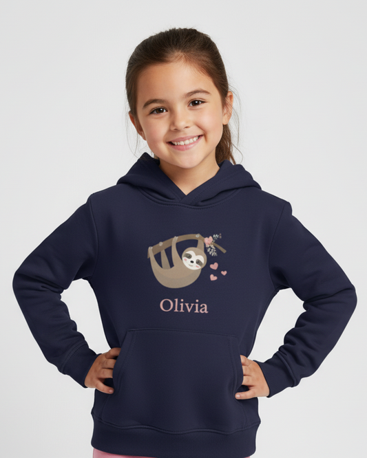 Smiling girl wearing a navy personalised kids hoodie with a cute sloth graphic and the name Olivia printed on the front, studio background