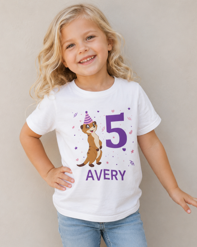 Blonde 4 year old girl wearing personalised white meerkat 5th birthday t-shirt with purple number print and name Avery, posing naturally in studio background