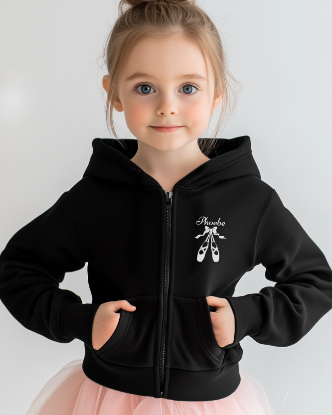 Young girl wearing a black hoodie with a ballet-themed design on a plain background