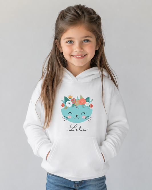 Young girl wearing a white hoodie featuring a cat design and floral elements with a name - studio setting