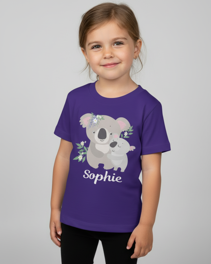 Young girl modelling a purple personalised koala T-shirt with the name Sophie, relaxed pose in a studio on a soft grey background.