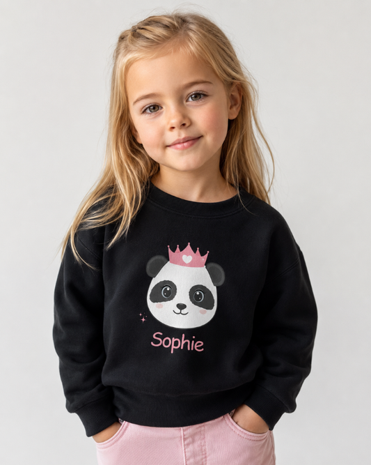 Girl modelling a personalised panda princess sweatshirt in black with custom name “Sophie”.