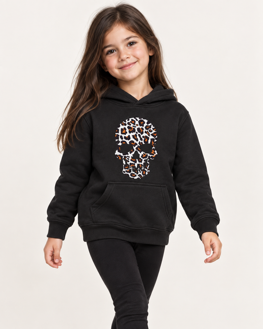 Girl wearing a black hoodie with a white, black and orange leopard-print skull design