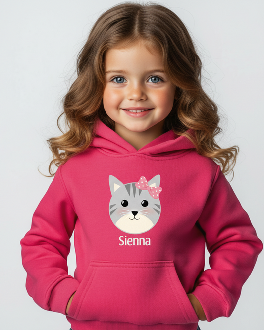 Child wearing a pink hoodie with a cat graphic and 'Sienna' text on a light gray background