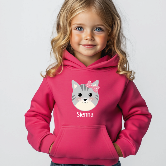 Girl wearing hot pink personalised cat hoodie with kitten face and pink bow, custom name printed on chest -fun everyday outfit for ages 3-13