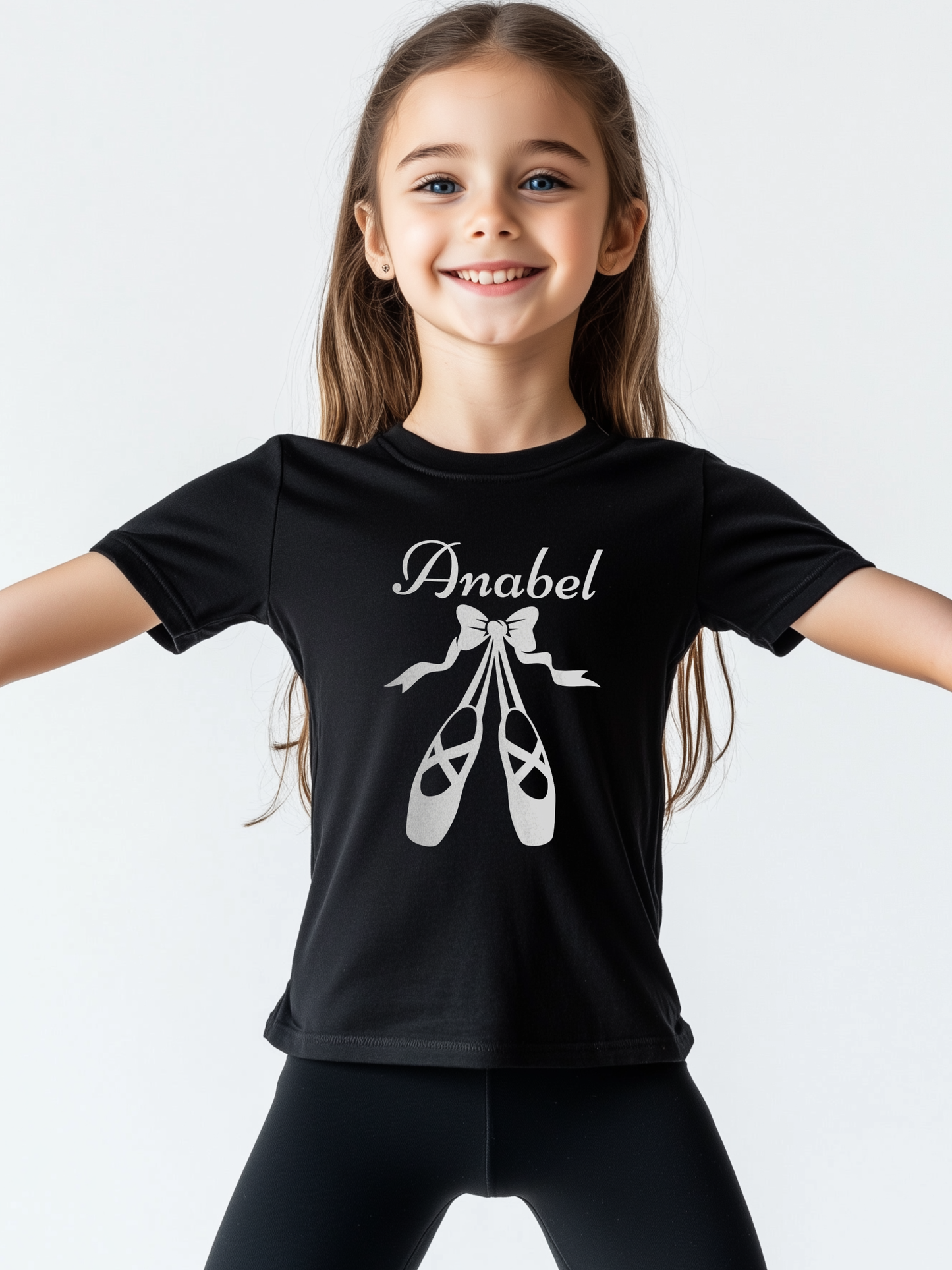 Young wearing a black t-shirt featuring white ballet shoes and bow graphic with personalised name printed on the chest.