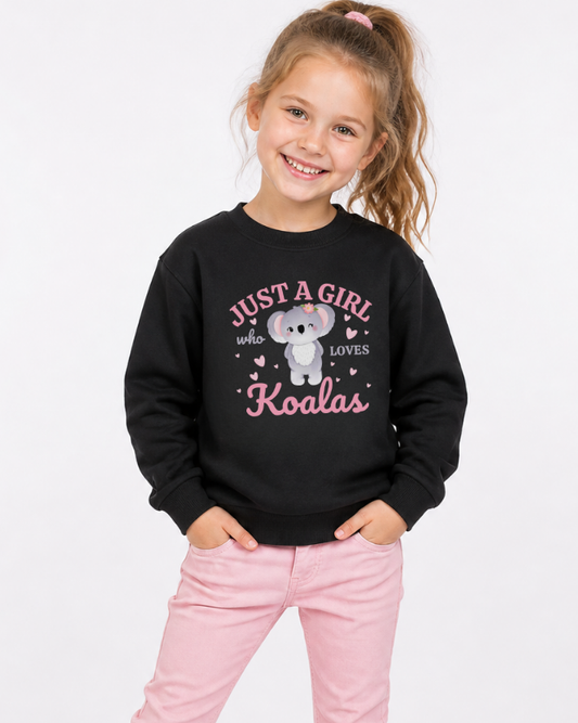 Girls black “just a girl who loves koalas” sweatshirt with cute koala graphic, worn by child with pink jeans, kids animal lover jumper UK