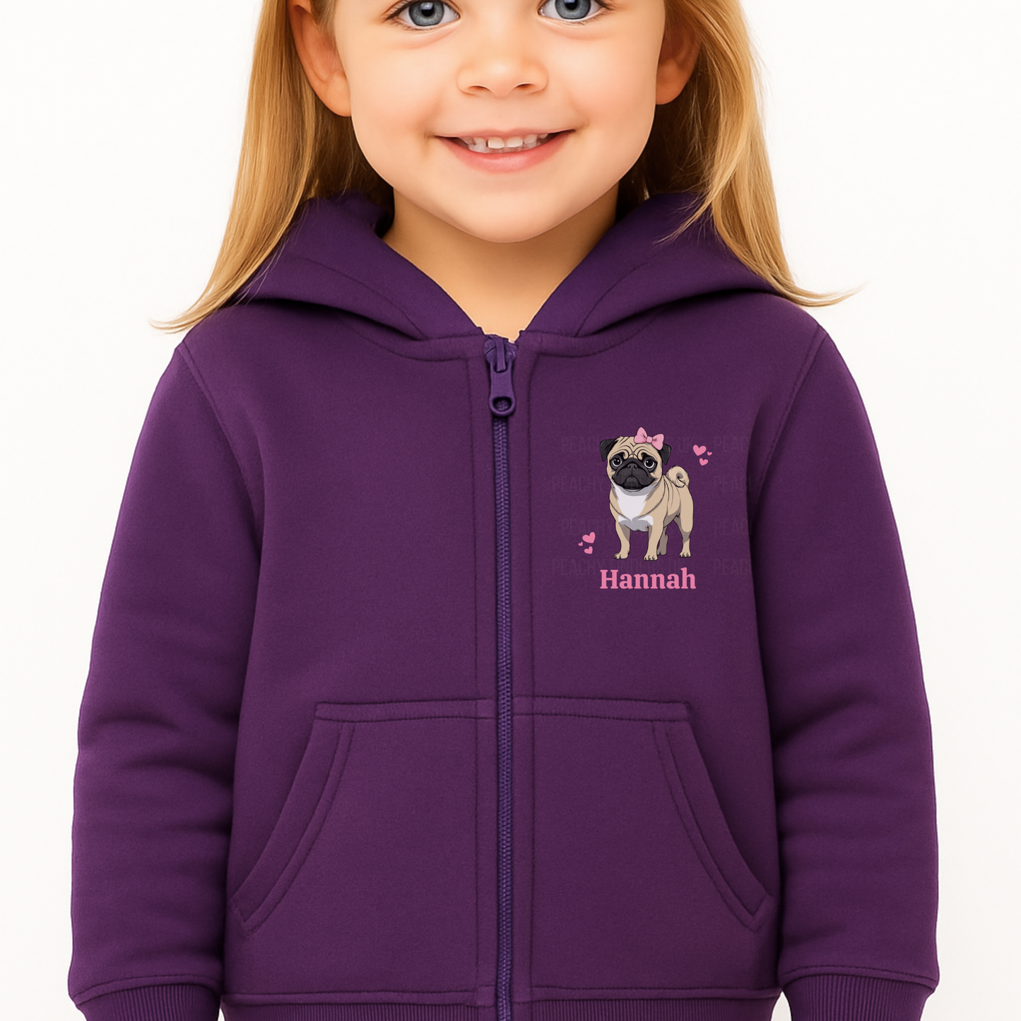 “Smiling young girl wearing a purple zip-up hoodie featuring a cute pug graphic with a pink bow and hearts, personalised with the name ‘Hannah’ printed underneath
