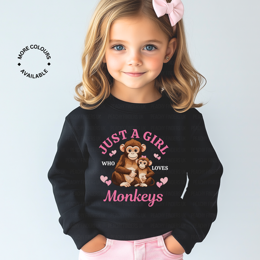 Young girl wearing a light pink jeans and a black sweatshirt with 'Just a girls who loves monkeys' printed graphic.
