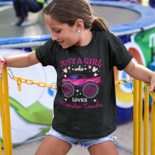 Smiling girl at fairground wearing black “Just a Girl Who Loves Monster Trucks” t-shirt with pink monster truck graphic