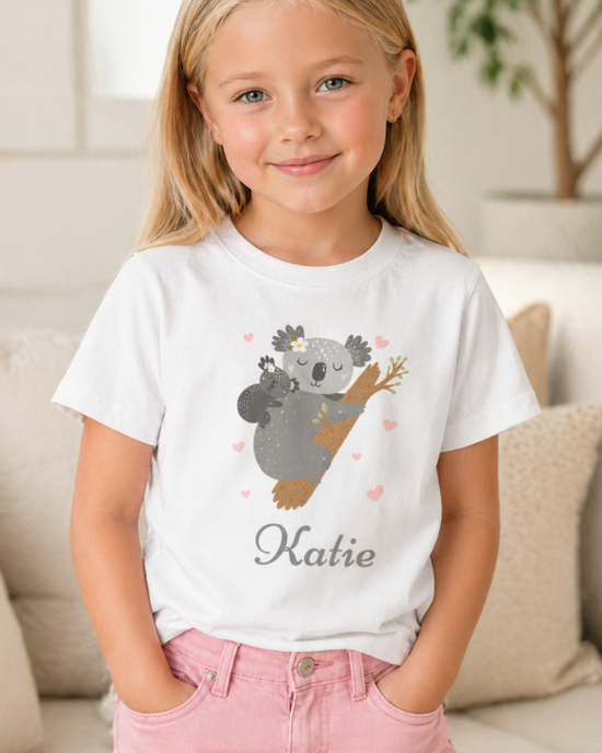 Girl wearing personalised white koala cotton T-shirt with pink jeans indoors lifestyle photo
