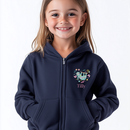 Young girl wearing a navy zip hoodie with cute sloth surrounded by flowers and butterflies forming a heart shape, personalised with child’s name.