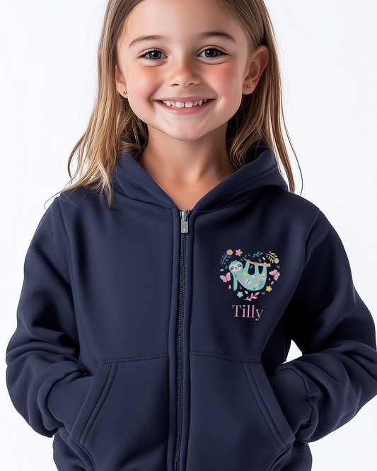 Young girl wearing a navy zip hoodie with cute sloth surrounded by flowers and butterflies forming a heart shape, personalised with child’s name.