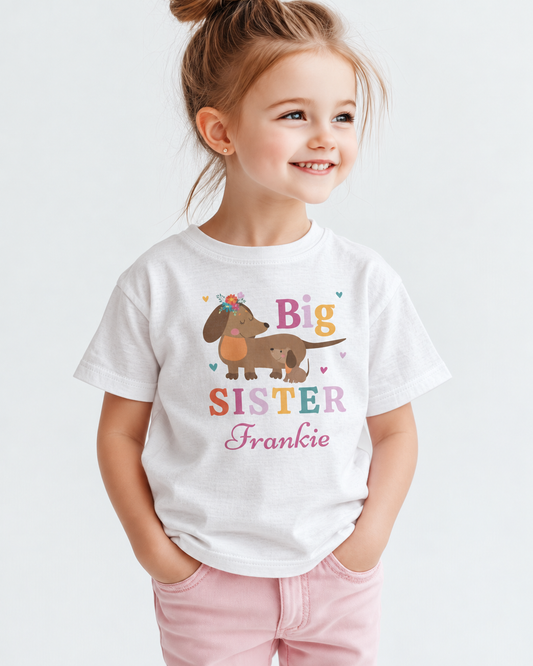Young girl wearing a white personalised Big Sister Frankie T-shirt featuring a mother dachshund and puppy design.