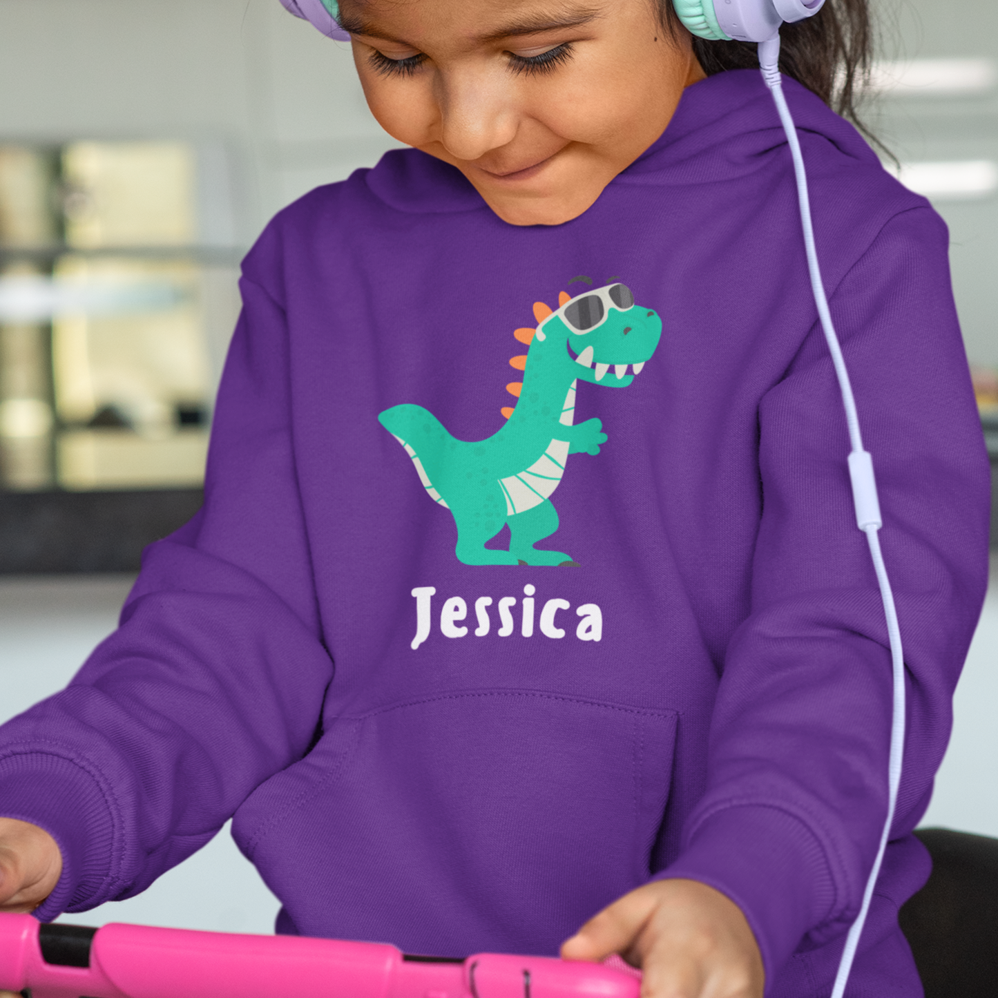 Girl wearing personalised purple kids hoodie with cool dinosaur in sunglasses and custom name on front