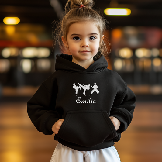Child wearing a black hoodie with three silhouettes of female martial artists and name.