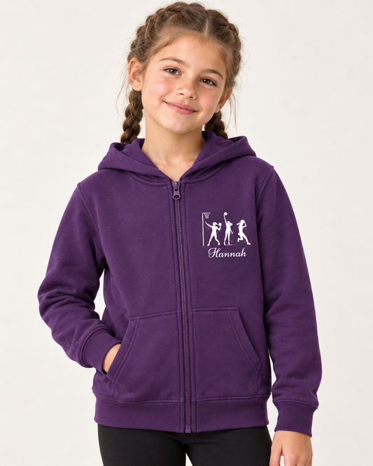 Girl with French plaits wearing a purple personalised netball zip hoodie and black leggings in a bright studio.