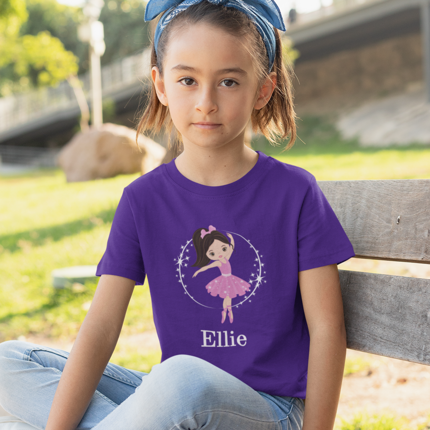 Smiling girl wearing purple personalised ballerina t-shirt with pink tutu design and custom name printed below.