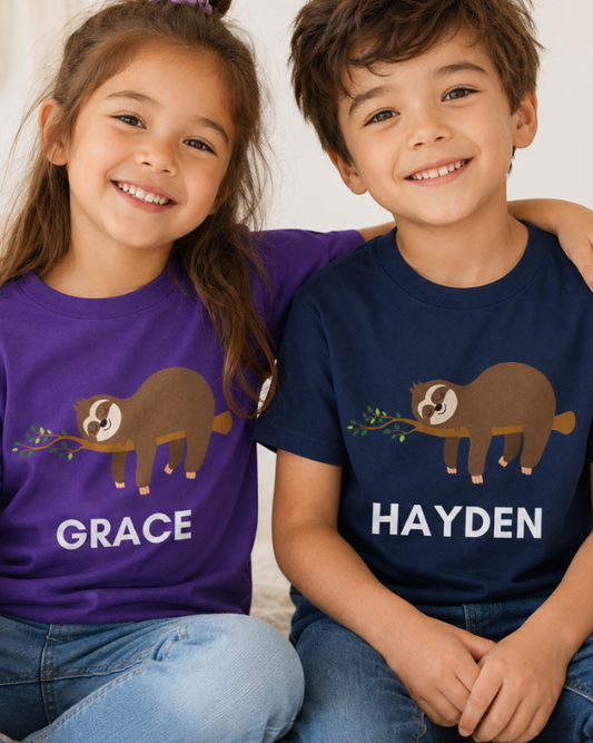 A girl and boy wearing navy and purple t-shirts with a sleeping sloth graphics and names 'Grace' and 'Hayden'.