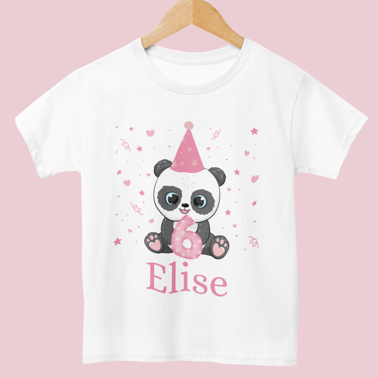 White cotton girls birthday t-shirt featuring a cute panda in a pink party hat holding a number with confetti, stars and hearts around, styled on a wooden hanger
