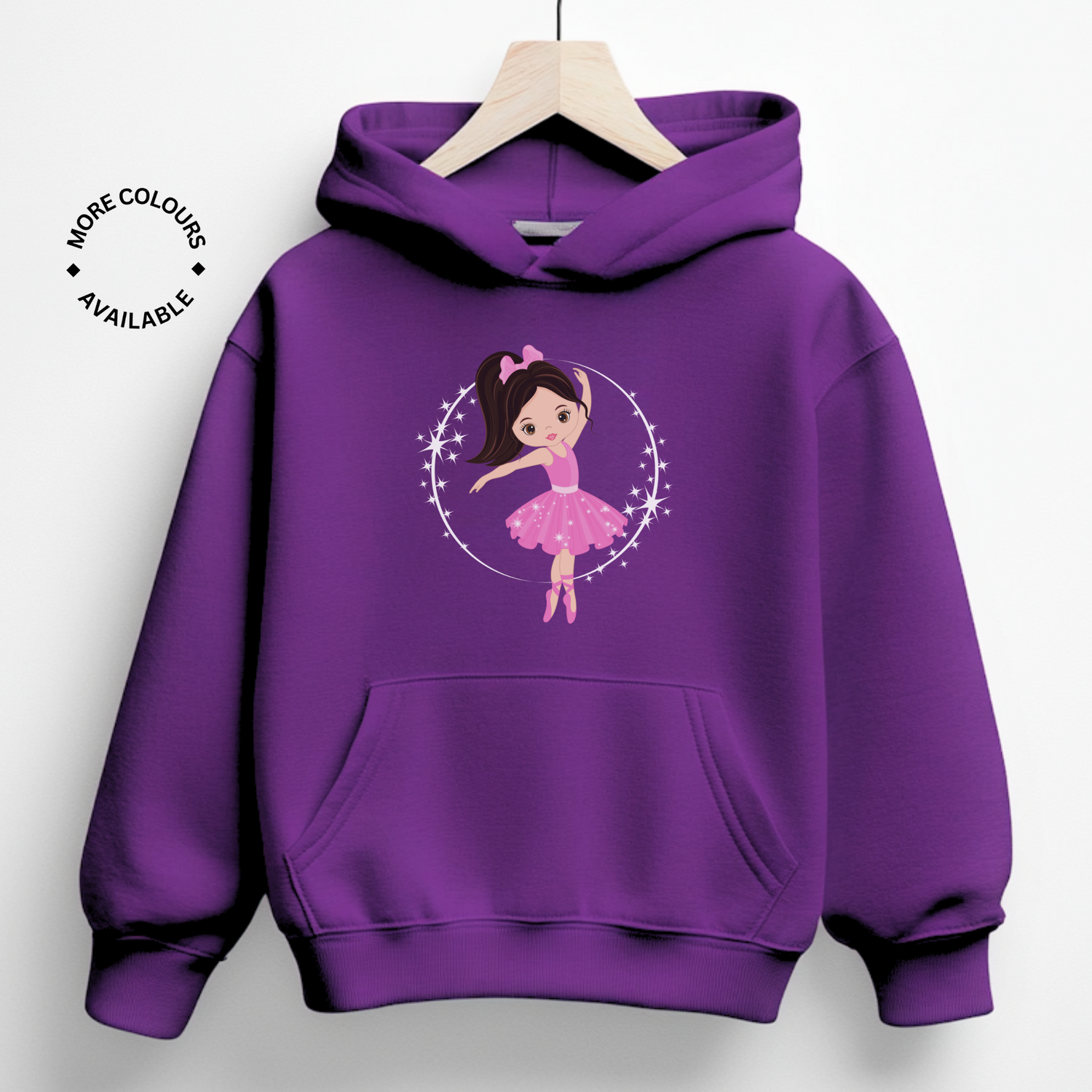 A kids purple hoodie displays a white circle containing a cartoon illustration of a ballerina with dark hair tied in a ponytail with a pink bow. The ballerina is wearing a pink tutu and pink ballet shoes and is posed mid-dance.