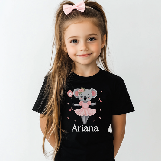 Young girl wearing a black t-shirt featuring a cute ballerina koala holding a balloon, personalised with name and age.