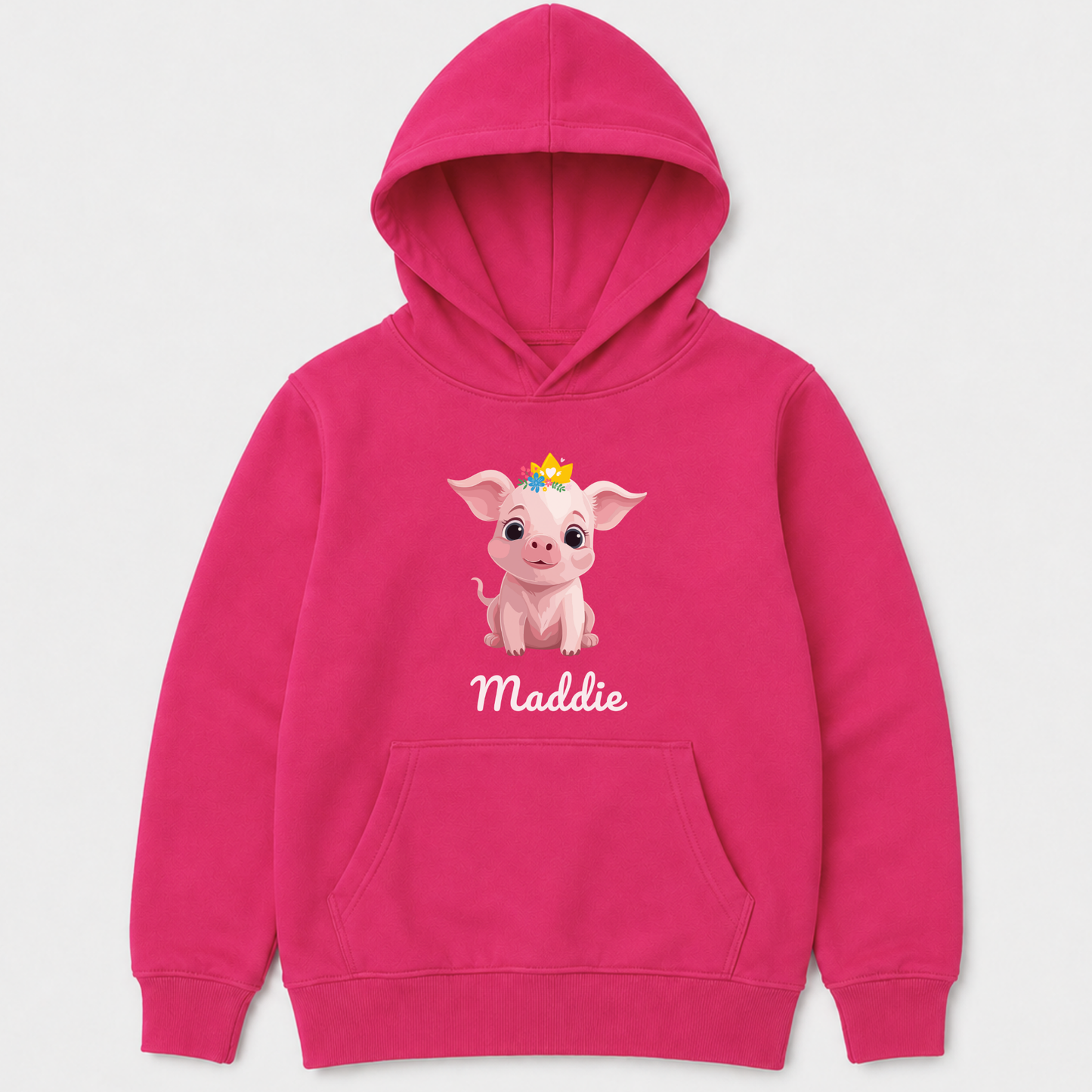 A hot pink girls pullover hoodie with a graphic of a cute cartoon pig wearing a small yellow crown and the name 'Maddie' printed below in white script. The hoodie is shown against a light grey background.