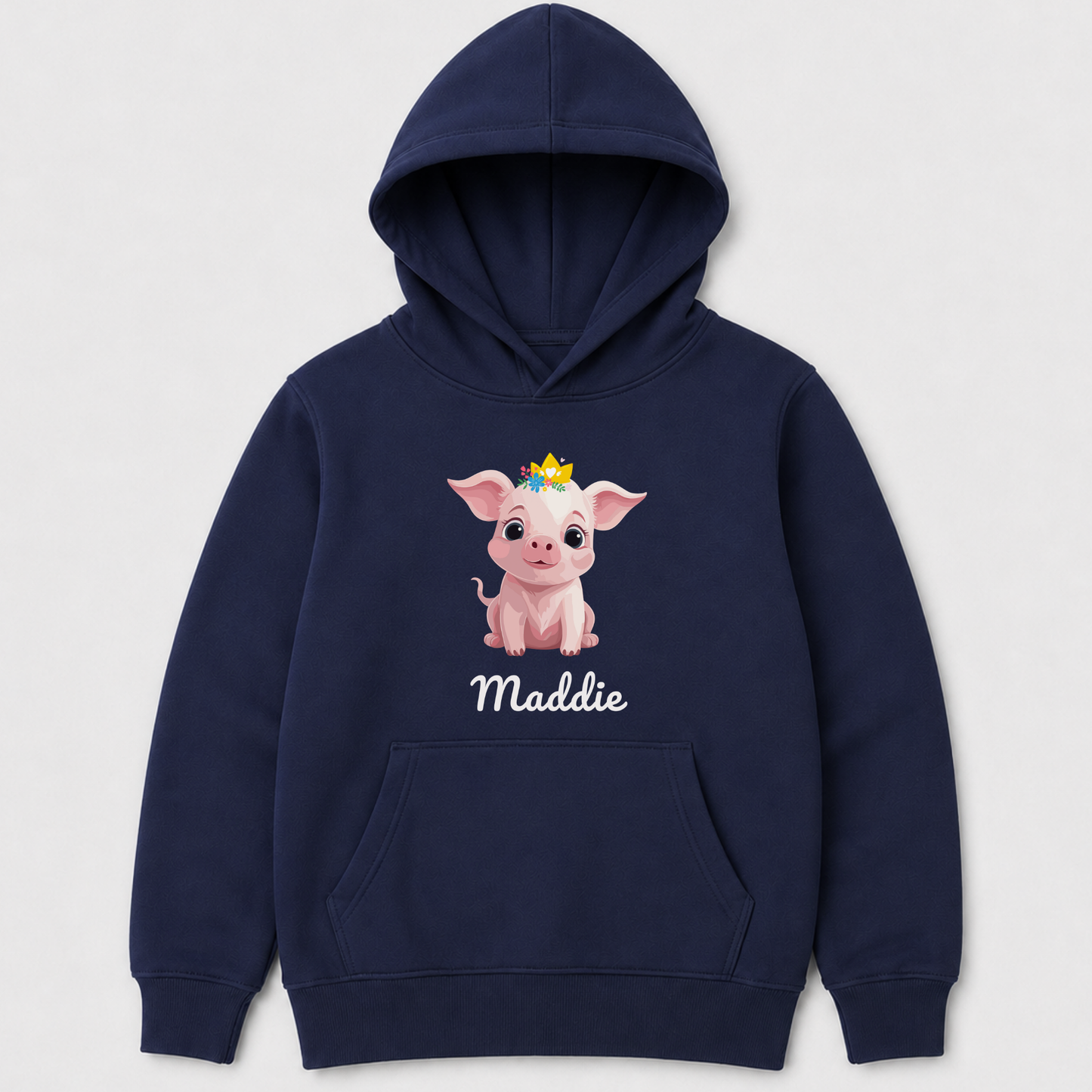 A navy blue kids pullover hoodie featuring a cartoon graphic of a pink pig wearing a small gold crown, with the name 'Maddie' printed in white script below. The hoodie is shown against a light gray background.
