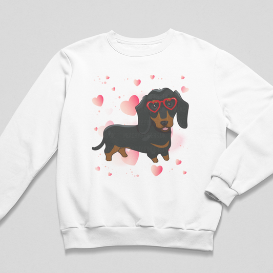 Girls sweatshirt in white featuring a cute Dachshund in red heart shaped glasses surrounded by hearts.