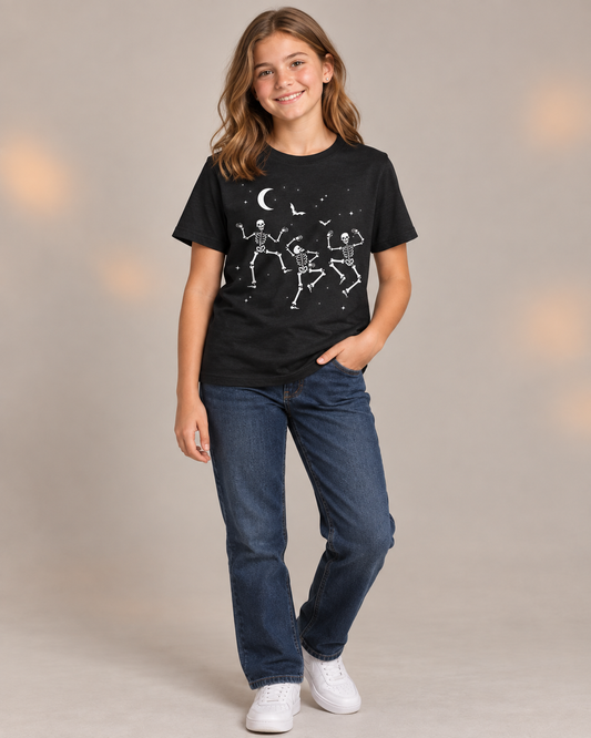 Girl wearing a black dancing skeletons Halloween T-shirt with straight-leg jeans and white trainers.