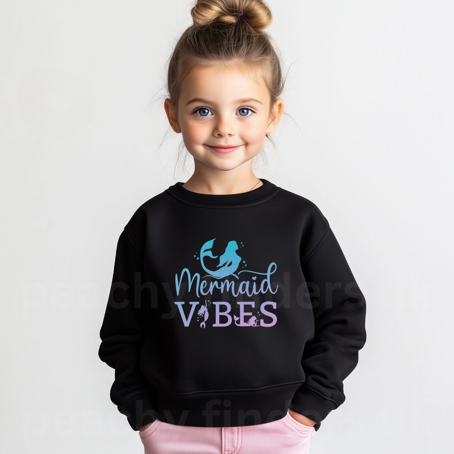 Young girls wearing a black sweatshirt with 'Mermaid Vibes' text and mermaid graphic.