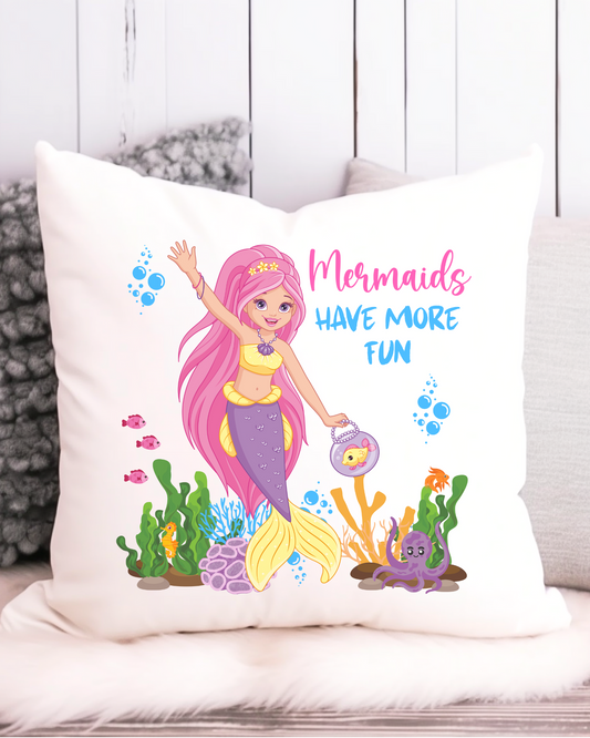 A cushion cover featuring a vibrant illustration of a mermaid with pink hair, wearing a yellow and purple outfit, in an underwater scene with a text 'Mermaids Have More Fun'.