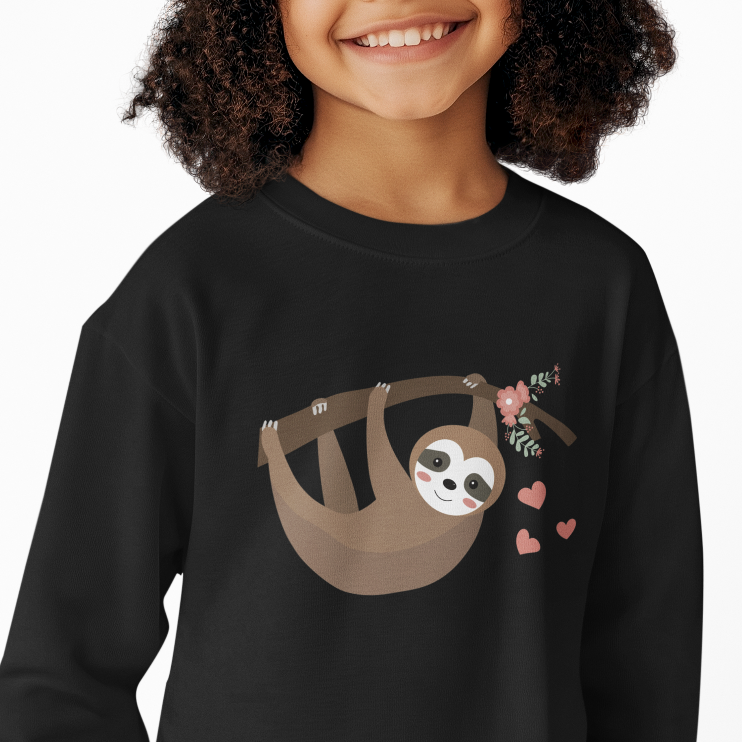 Young girl wearing a black sweatshirt featuring an adorable sloth hanging from a flower-decorated branch with pink hearts, displayed flat on a white background.
