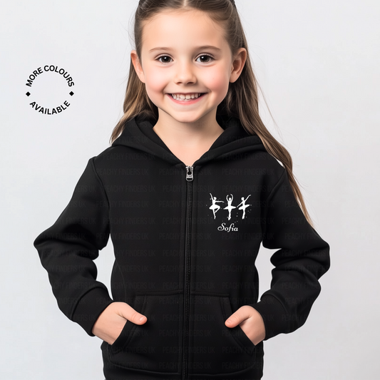 A young girl wearing a black zip hoodie featuring three white ballerina silhouettes and a personalised name print on the front