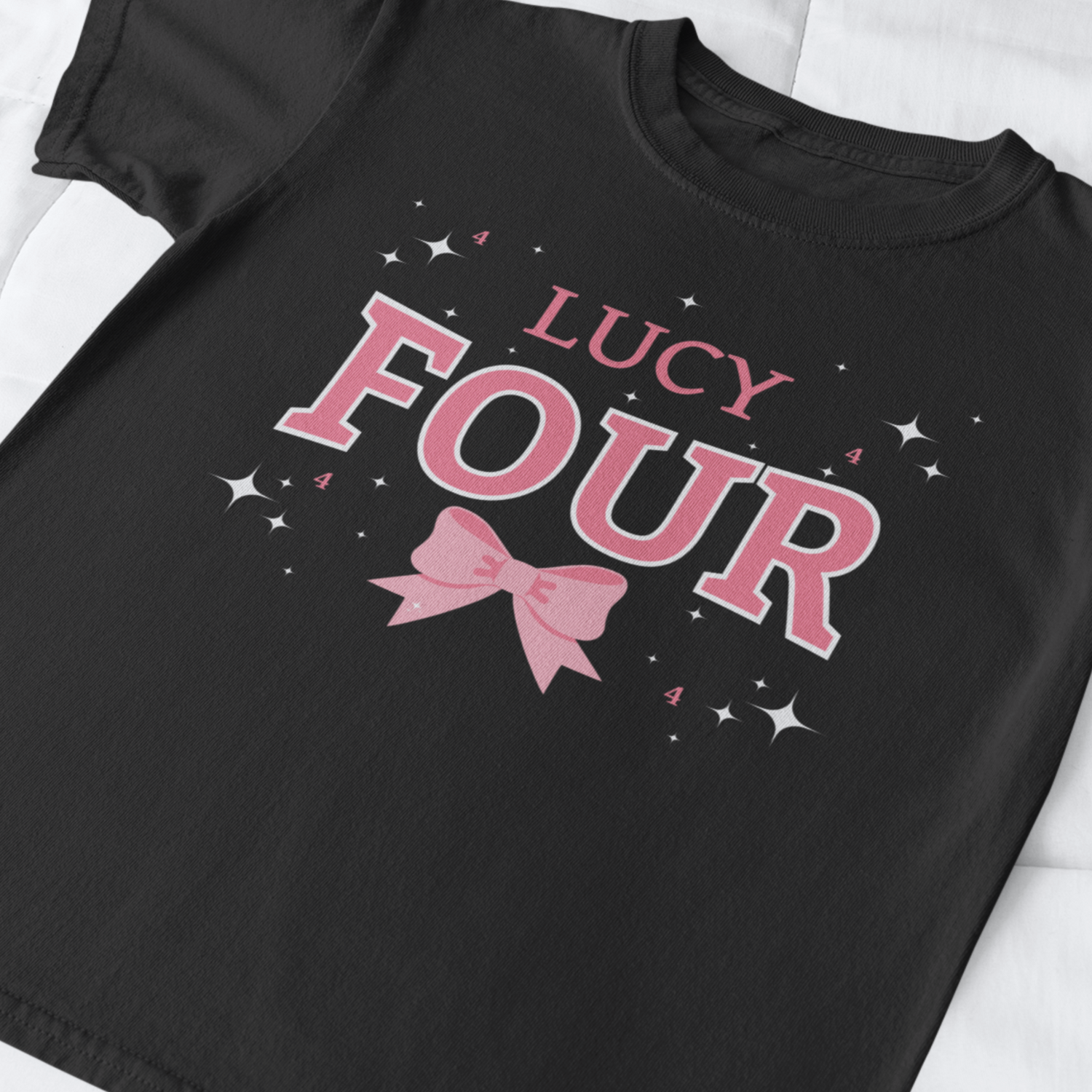 A girls short sleeved t-shirt in black featuring a bold pink and white number “Four” with pink bow, stars and custom name 'Lucy' - flat lay.