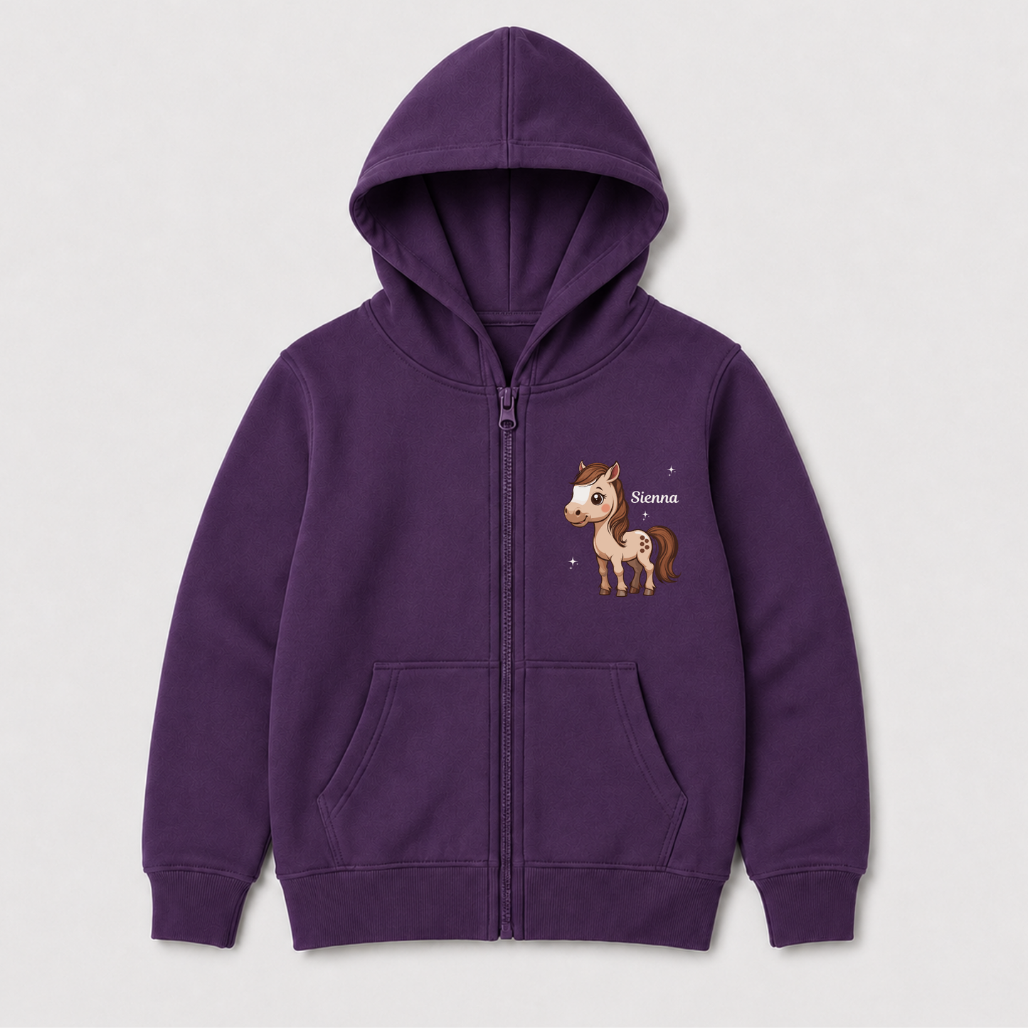 A girls purple zip-up hoodie for kids, featuring a cartoon horse graphic on the left chest with the name 'Sienna' written next to it, displayed on a light grey background.