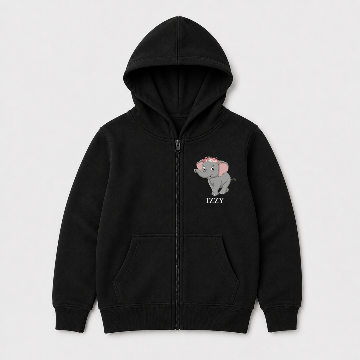 A girls black zip-up hoodie with a front kangaroo pocket, featuring a sweet elephant wearing a floral crown on the left chest with the name 'IZZY' printed below it, flat lay against a light grey background.