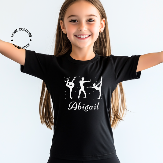Young girls wearing a black t-shirt with printed white graphic silhouettes of three gymnasts and her name underneath.