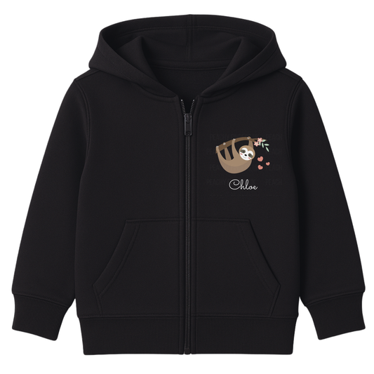 Kids black zip-up hoodie with hanging sloth, floral branch, pink hearts, and personalised name printed on the chest, displayed on a white background.