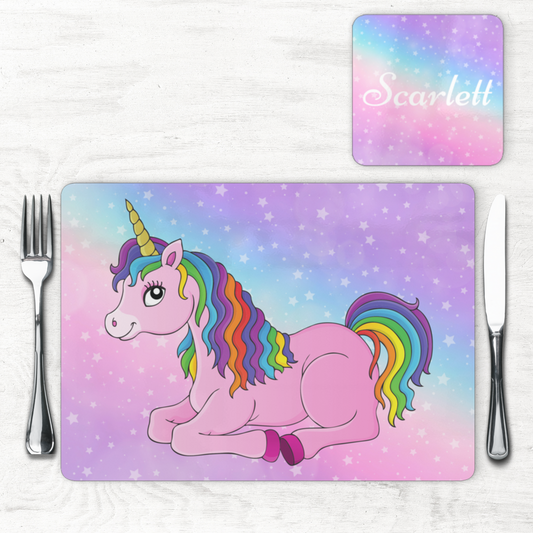 Personalised girls unicorn placemat and coaster set featuring a pink unicorn with a rainbow mane on a pastel star background. The coaster includes the name “Scarlett” in white script text.