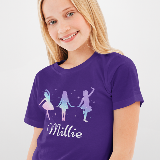 Girl wearing a purple personalised dance t-shirt featuring three pastel silhouette dancers with stars and the name “Millie” printed below.