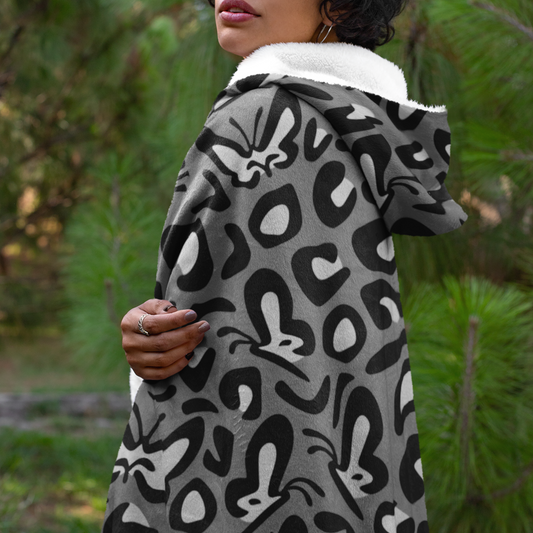 A black and white leopard print patterned hooded blanket 