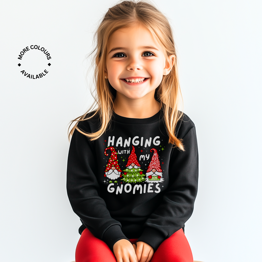 Smiling young girl wearing a black Christmas sweatshirt with “Hanging with my Gnomies” festive gnome design.