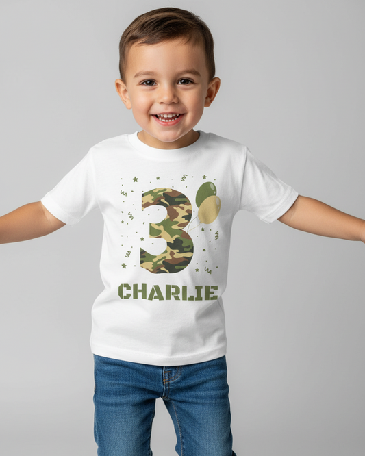 Smiling young boy wearing a white personalised birthday T-shirt with a camouflage number 3 and the name Charlie.