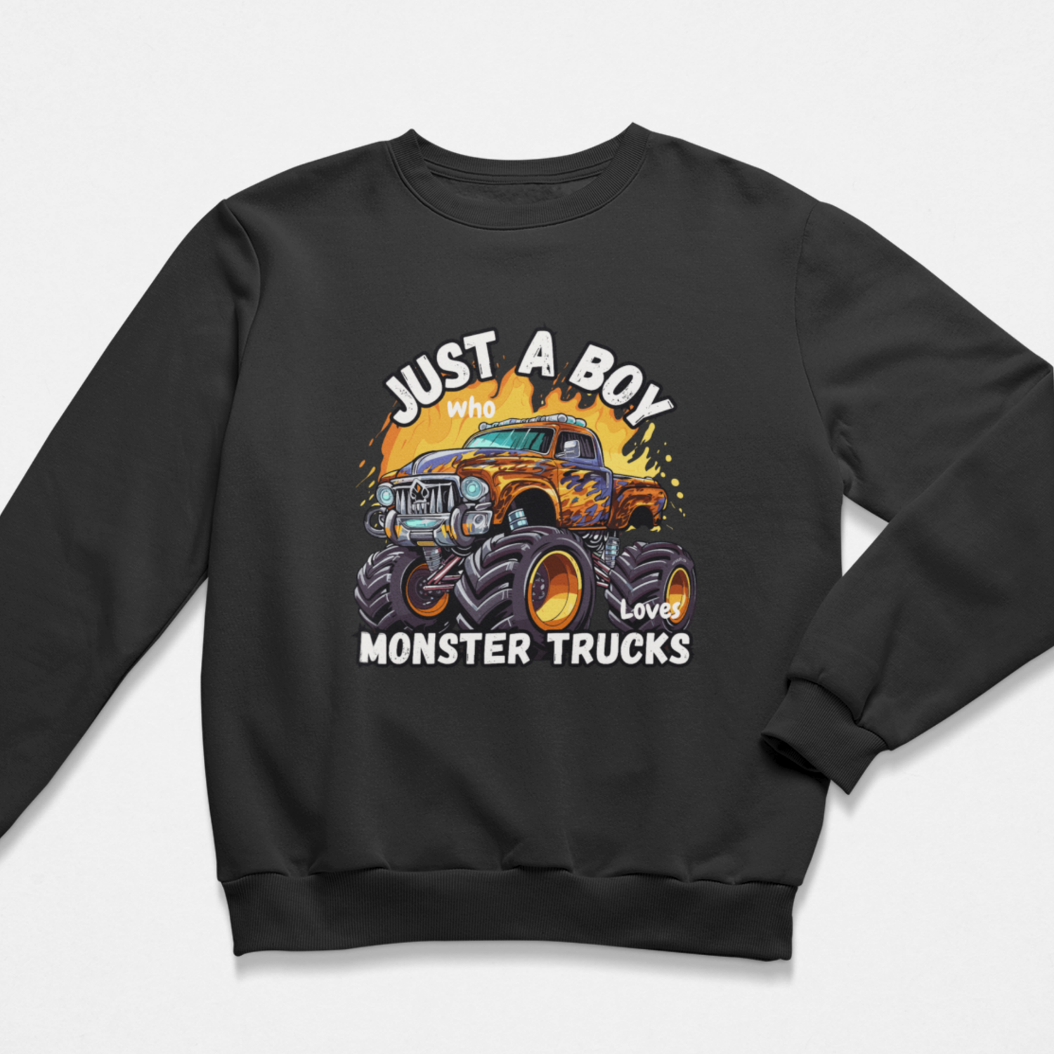 Kids Just A Boy Who Loves Monster Trucks sweatshirt in black with colourful monster truck graphic, shown as a flat lay product mockup.