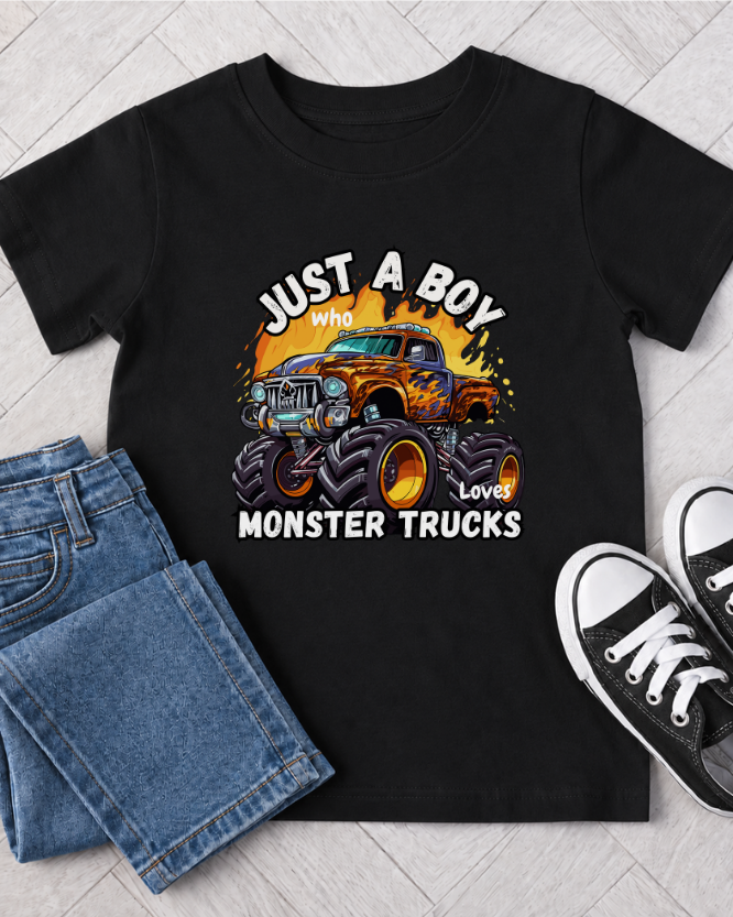 Boys black monster truck T-shirt outfit flat lay with jeans and trainers, featuring a colourful “Just A Boy Who Loves Monster Trucks” design.
